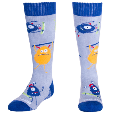 Hot Chillys kids thermal ski socks with blue cuffs and colorful monster designs on light gray background