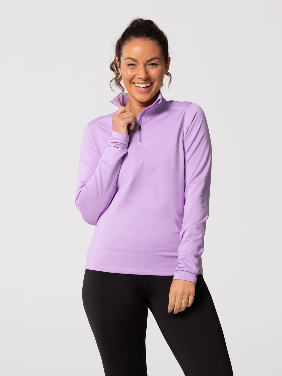 Front view of smiling woman wearing Hot Chillys Micro-Elite Chamois Zip-T in light lavender with matching black tights