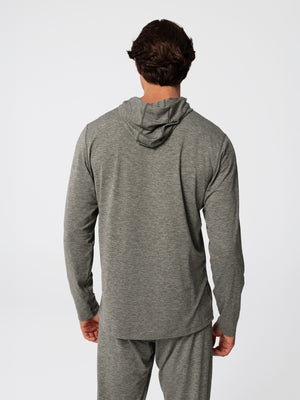 Man wearing Hot Chillys Clima-Tek hoodie and bottom base layer set in dark olive, back view