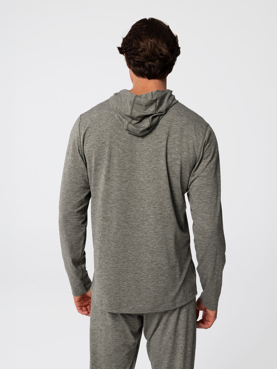 Man wearing Hot Chillys Clima-Tek hoodie and bottom base layer set in dark olive, back view