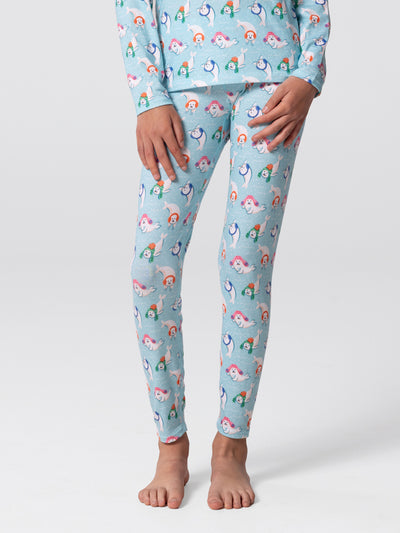 Close-up of legs of youth wearing Hot Chillys Originals Winter Seals print leggings in light blue