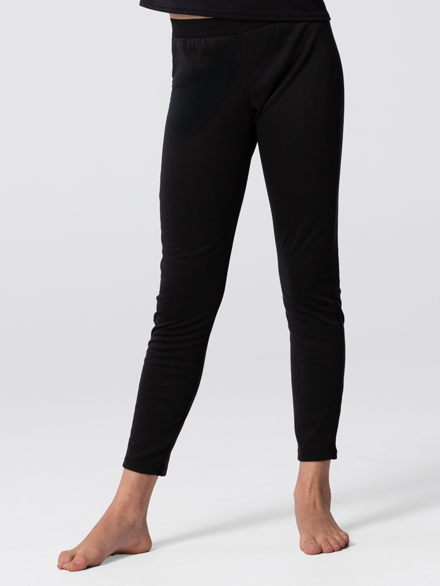 Close-up of legs of youth wearing Hot Chillys Pepper Bi-Ply black thermal bottoms