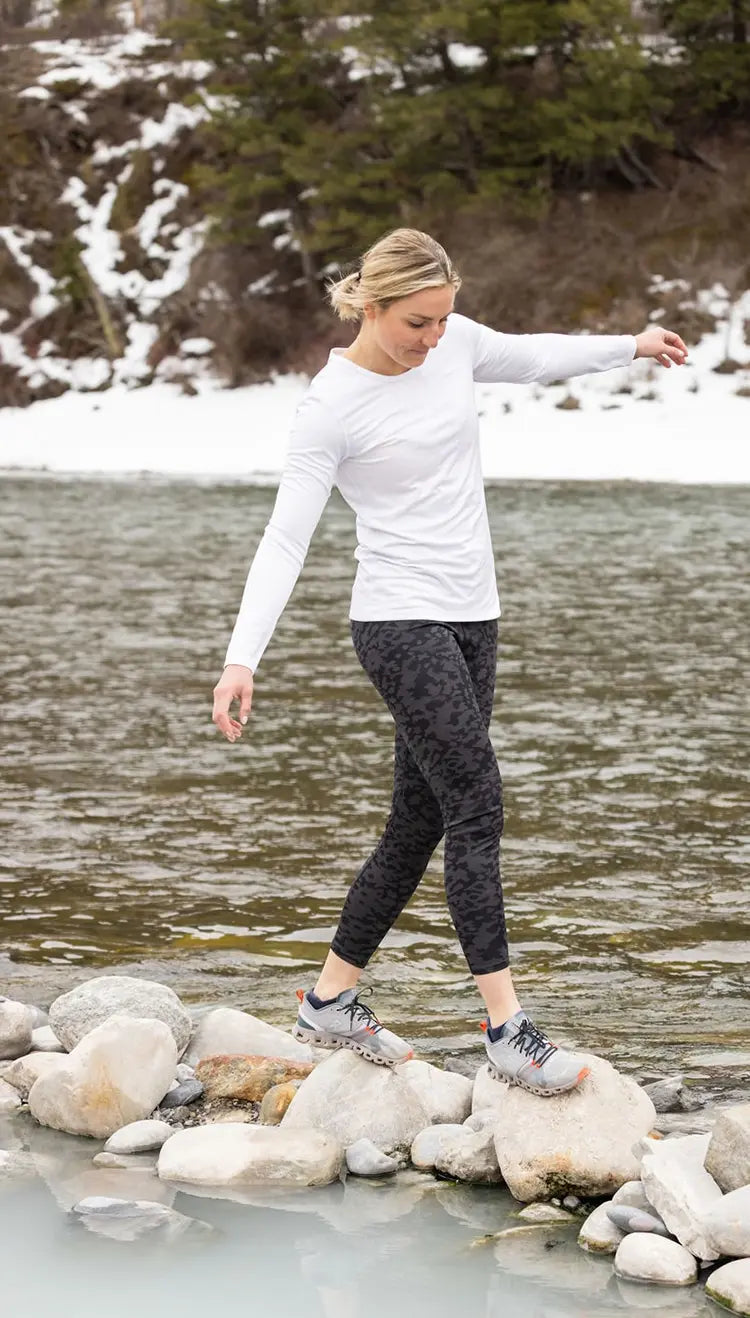 Woman wearing Hot Chillys thermal baselayers next to a river