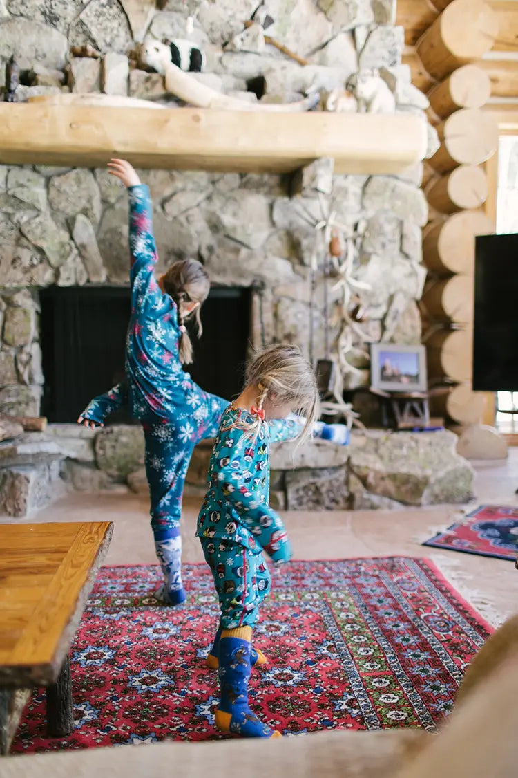 Kids playing wearing thermals in a cabin